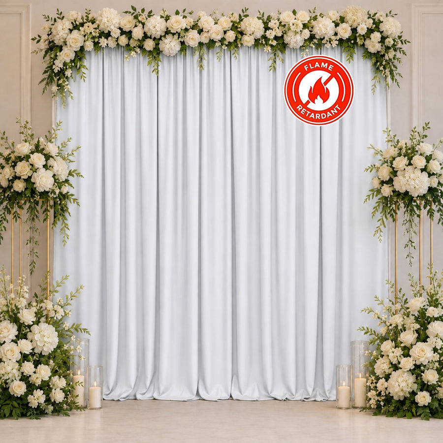 Elegant white floral wedding backdrop with fire retardant drapery and candles