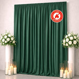 Green flame-retardant wedding backdrop with white floral arrangements and candles