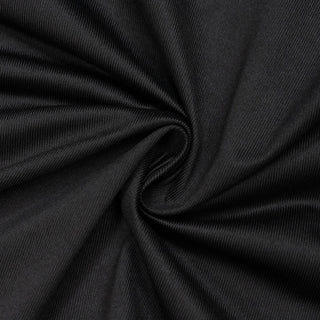 Black ribbed fabric texture with soft spiral folds and draped pattern