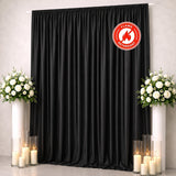 Black flame-retardant curtain with white floral arrangements and candles on both sides