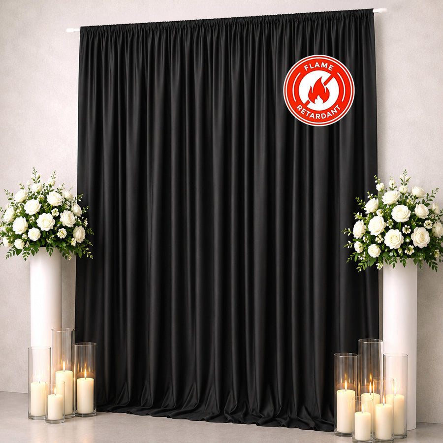 Black flame-retardant curtain with white floral arrangements and candles on both sides
