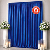 Blue flame-retardant curtain backdrop with white floral arrangements and candles