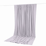 Light gray satin curtain draped on a rod, elegant fabric backdrop