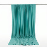 Teal draped satin fabric hanging on a rod, isolated on white background