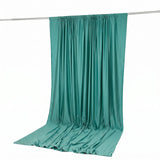 Teal satin curtain draped on a rod, studio product photo