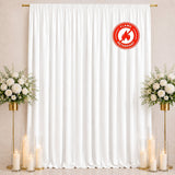 White flame-retardant curtain backdrop with floral arrangements and candles