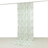 Floral patterned curtain in green and white hanging from a rod