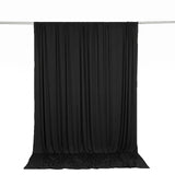 Black draped curtain backdrop hanging on a silver rod, studio background