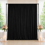 Black wedding backdrop with floral arrangements and candles by windows