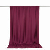 Burgundy velvet curtain draped on a rod against a white background