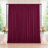Elegant burgundy velvet backdrop with floral arrangements and candles