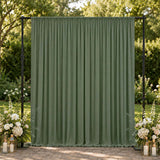 Green outdoor curtain backdrop with floral wedding decor in a garden setting