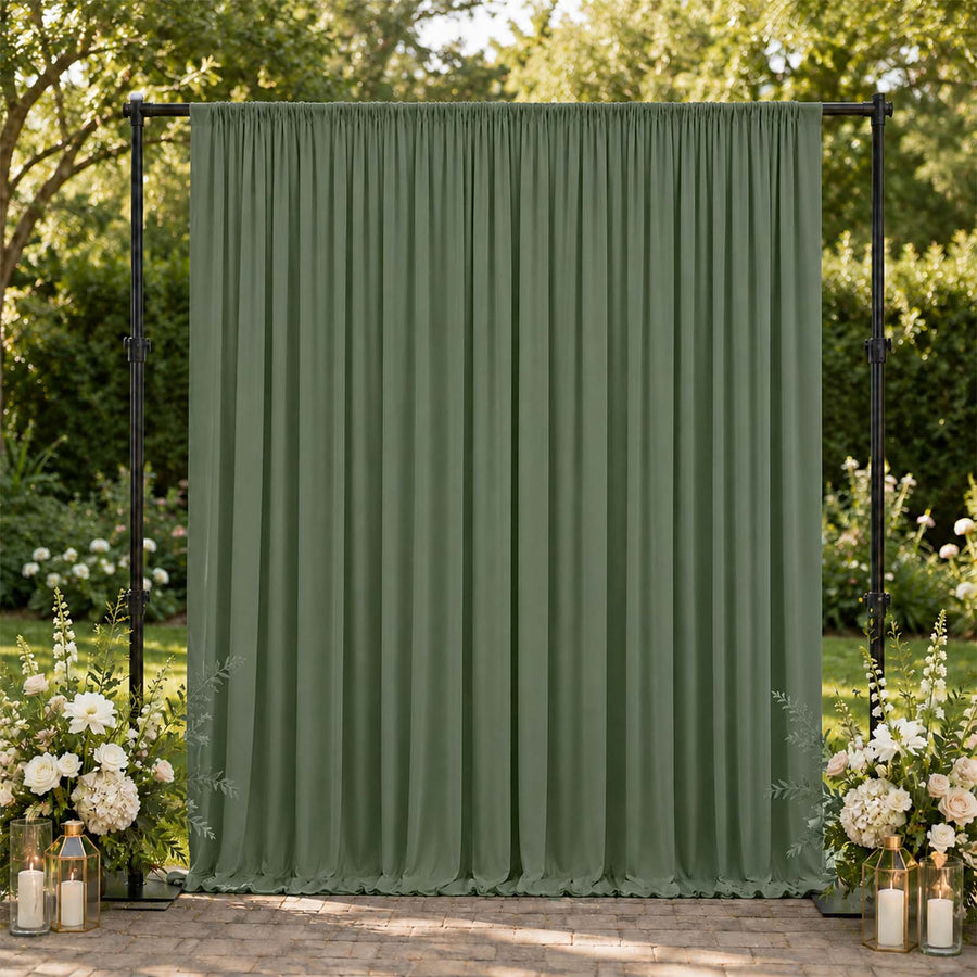 Green outdoor curtain backdrop with floral wedding decor in a garden setting