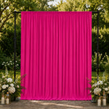 Bright pink outdoor event curtain backdrop with floral wedding décor