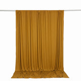 Mustard yellow draped curtain on hanging rod, studio backdrop