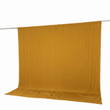 Gold fabric backdrop on hanging rod with floor sweep, studio background