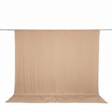 Beige seamless backdrop fabric hanging on a studio support rod#whtbkgd