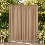 Beige wedding backdrop curtain with floral arrangements and lanterns outdoors
