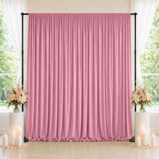 Pink draped backdrop with floral candle decor for wedding or event stage