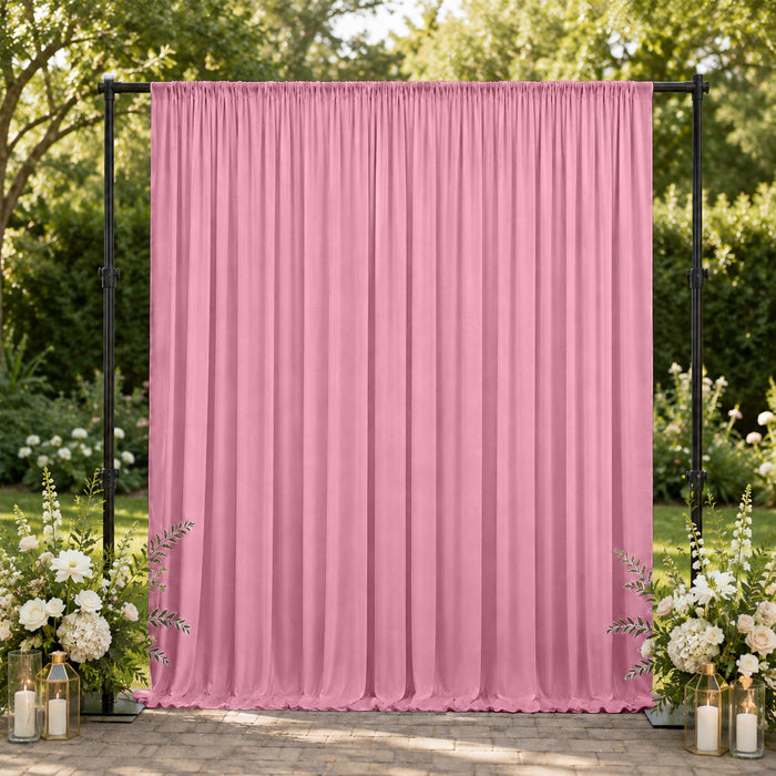 Pink wedding backdrop curtain with floral arrangements and lanterns outdoors