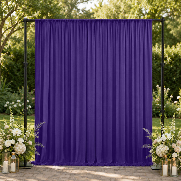 Purple event backdrop curtain with floral arrangements outdoors