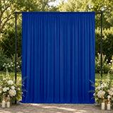 Blue event backdrop with floral arrangements and lanterns in an outdoor garden setting