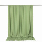 Light green draped fabric backdrop hanging on a studio rod