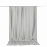Light gray draped curtain backdrop on hanging rod, studio background