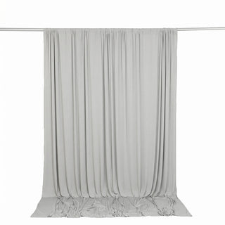 Light gray draped curtain backdrop on hanging rod, studio background