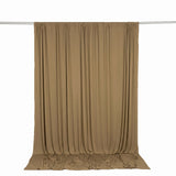 Beige backdrop curtain hanging on studio rod with draped fabric ends