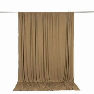 Beige backdrop curtain hanging on studio rod with draped fabric ends