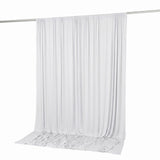 White sheer curtain hanging on a rod with soft draping on the floor
