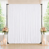 Elegant white wedding backdrop with floral arrangements and candles