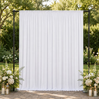 White wedding backdrop curtain with floral arrangements in an outdoor garden