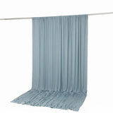 Light blue sheer curtain draped on a rod with pooled fabric on the floor