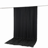 Black draped fabric backdrop on studio crossbar stand