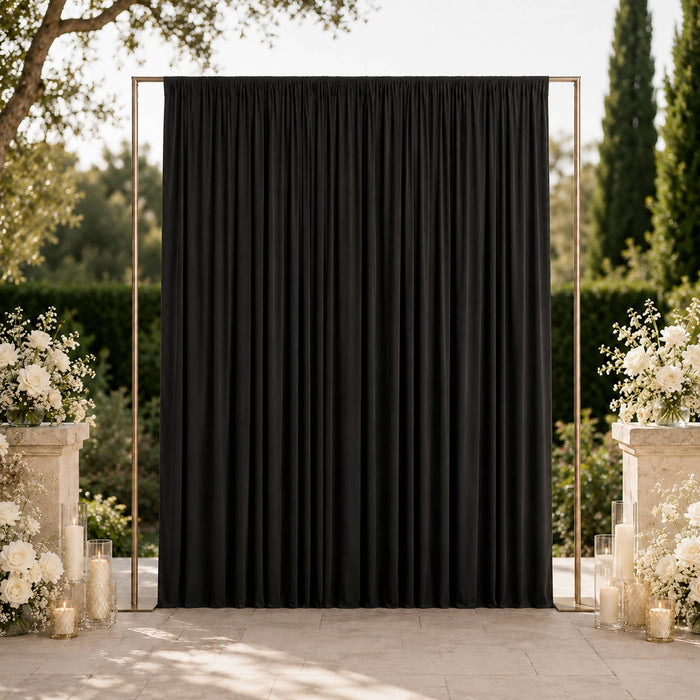 Elegant black wedding backdrop with white floral arrangements outdoors