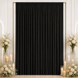Elegant black curtain backdrop with white floral arrangements and candles