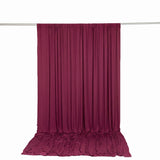 Burgundy draped fabric curtain backdrop on hanging rod