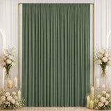 Elegant sage green curtain backdrop with white floral arrangements and candles