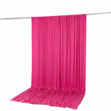 Bright pink draped fabric backdrop on a hanging rod, studio background