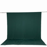 Dark green photography backdrop with floor sweep on support rod