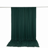 Dark green curtain draped on rod against white background