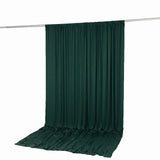 Dark green draped fabric backdrop with floor sweep on hanging rod