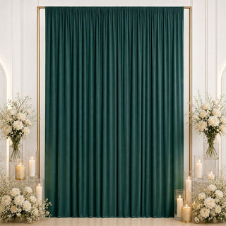Elegant emerald green curtain backdrop with white floral arrangements and candles