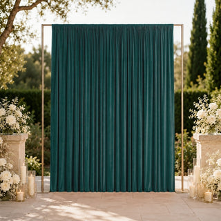 Elegant outdoor wedding backdrop with teal velvet curtain and white floral arrangements