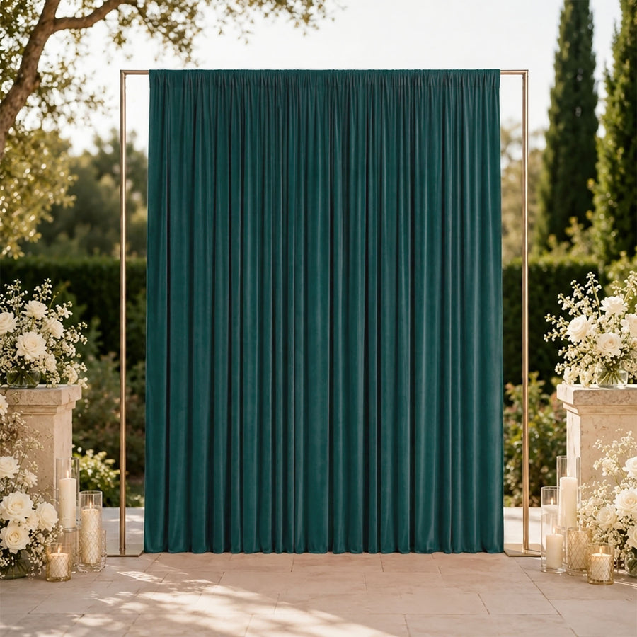 Elegant outdoor wedding backdrop with teal velvet curtain and white floral arrangements