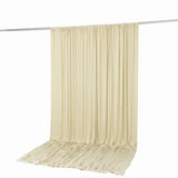 Cream pleated curtain panel hanging on rod, elegant draped fabric backdrop