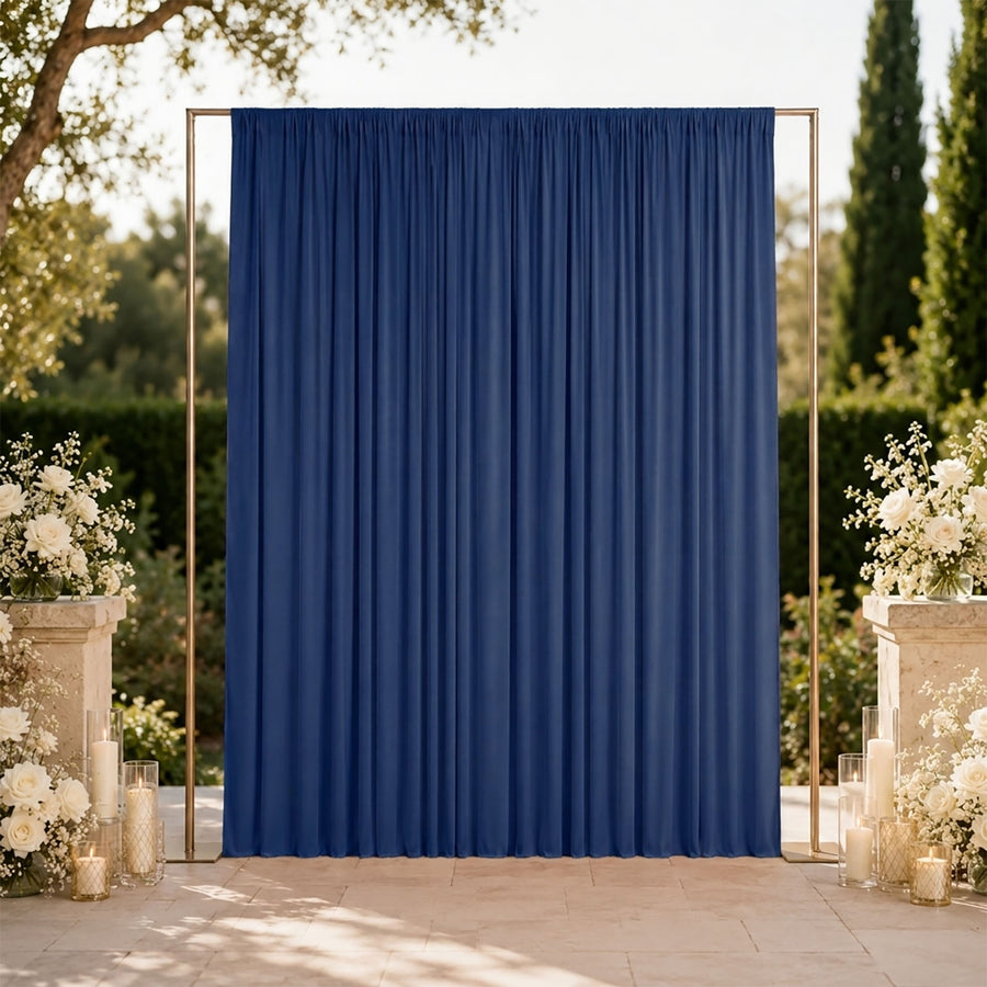 Blue wedding backdrop with gold frame, white floral arrangements, and candles