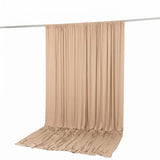Beige draped fabric backdrop with hanging curtain on rod, studio background